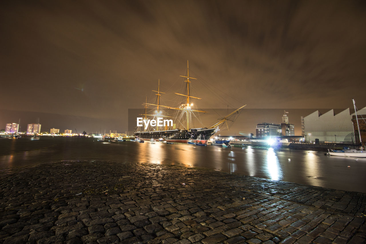 Illuminated ship moored in river at night