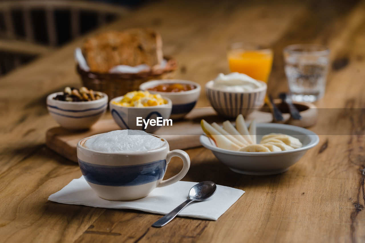 CLOSE-UP OF COFFEE CUP ON WOODEN TABLE