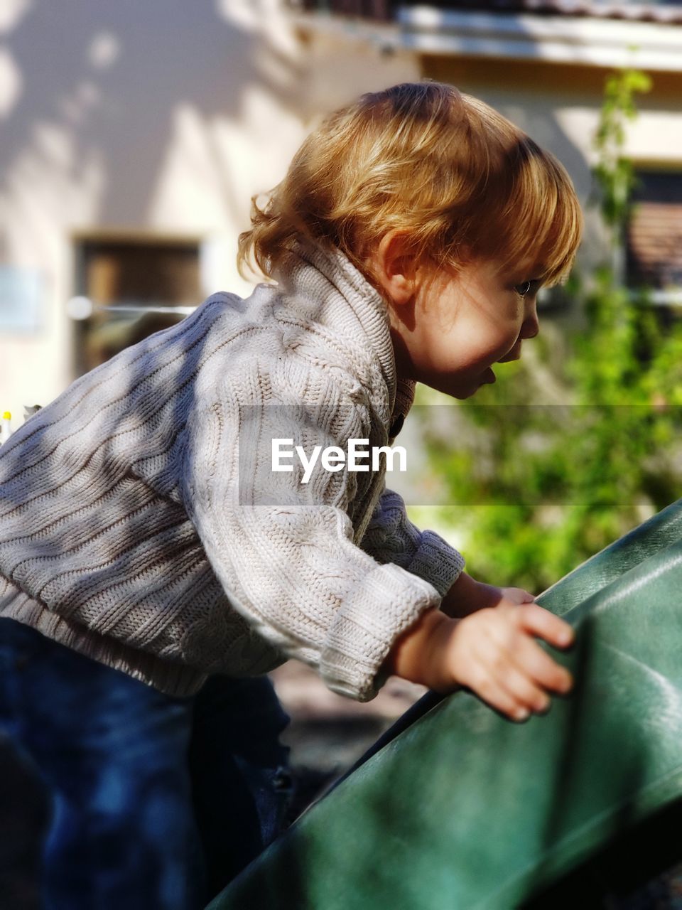 Side view of boy playing on slide at park