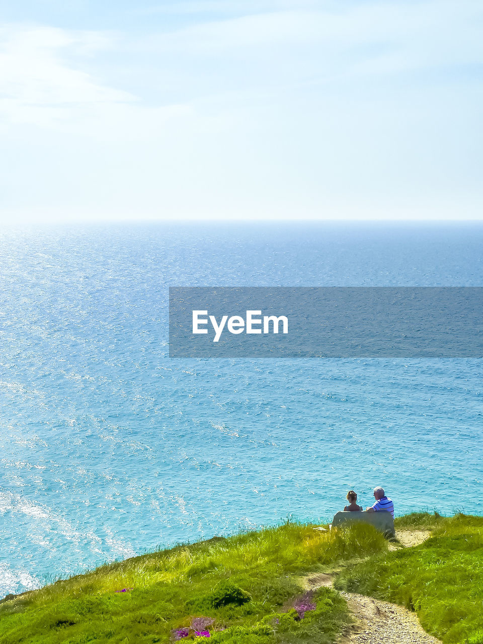 People sitting on bench at cliff