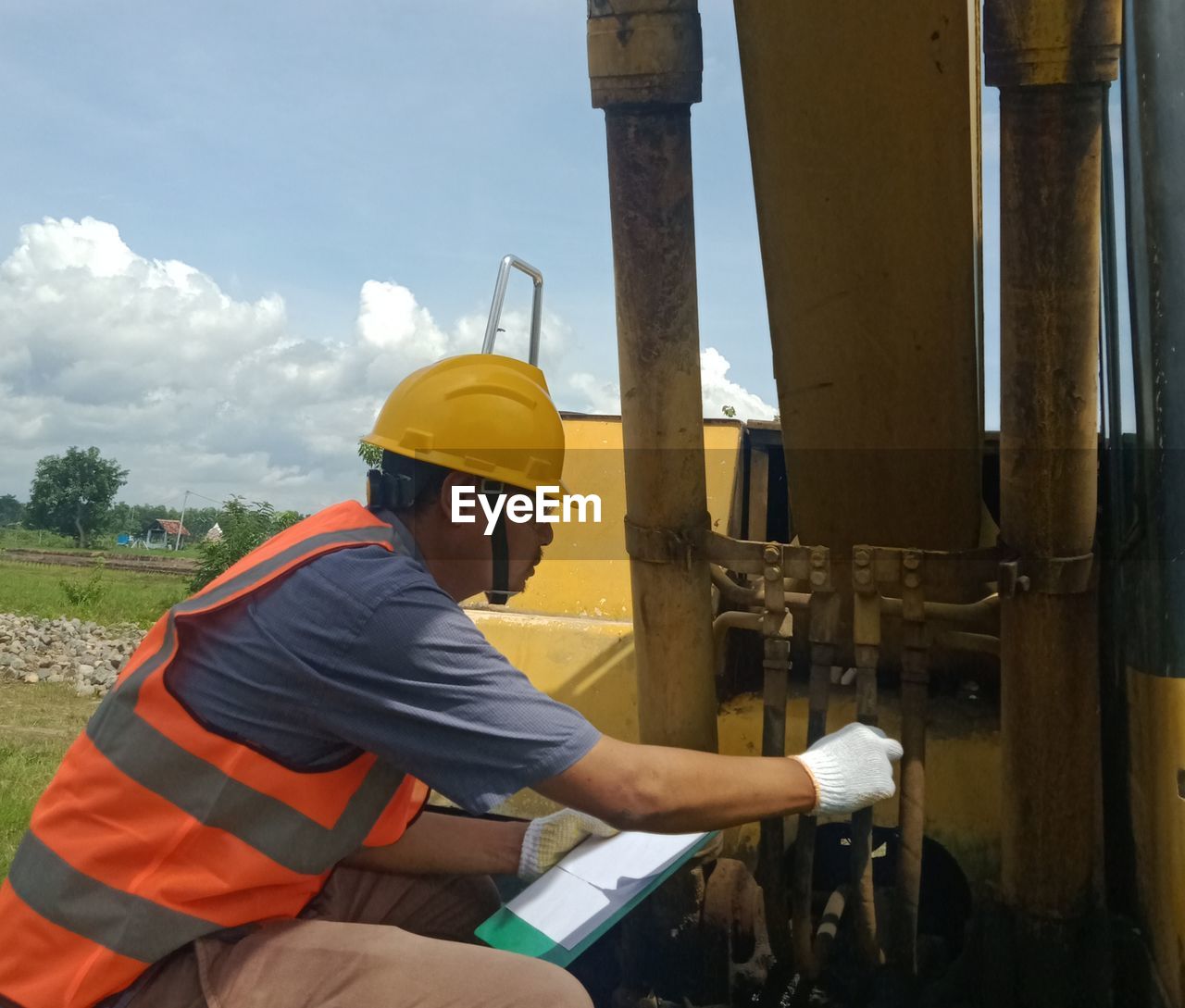 REAR VIEW OF MAN WORKING AT CONSTRUCTION SITE