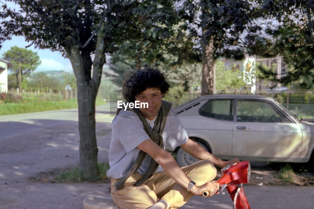 Side view of young man riding motorcycle in park