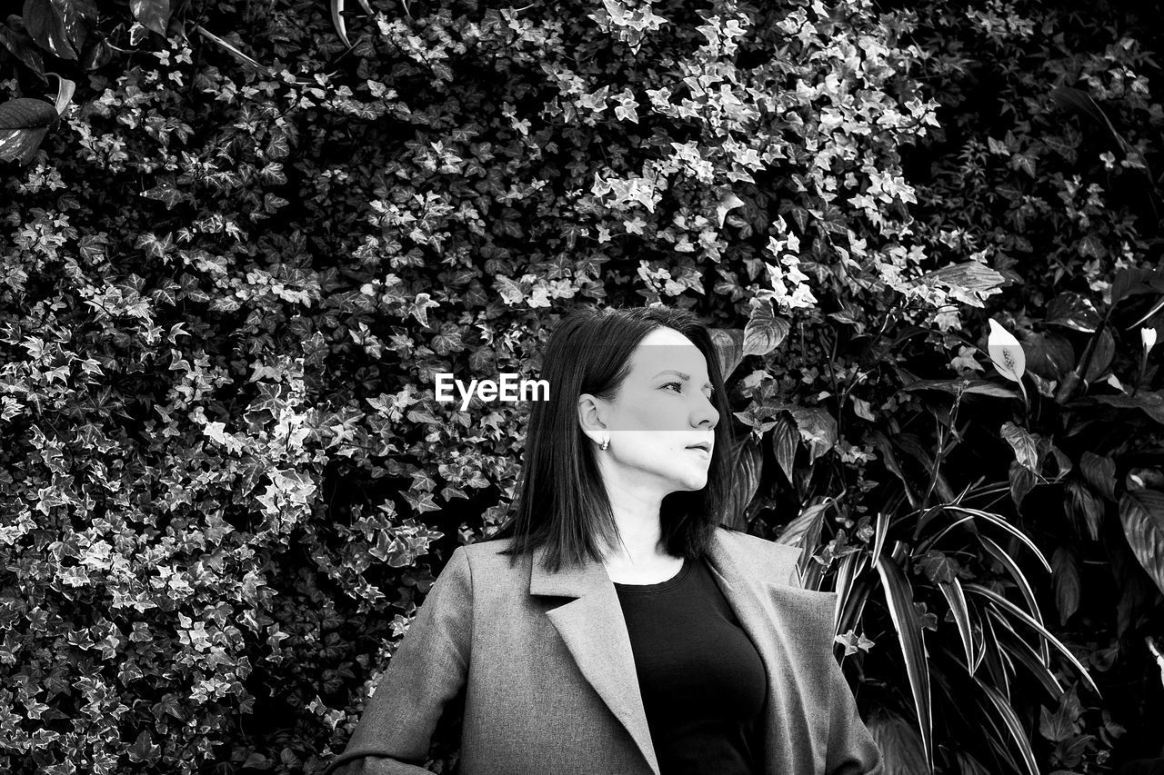 Woman standing against plants