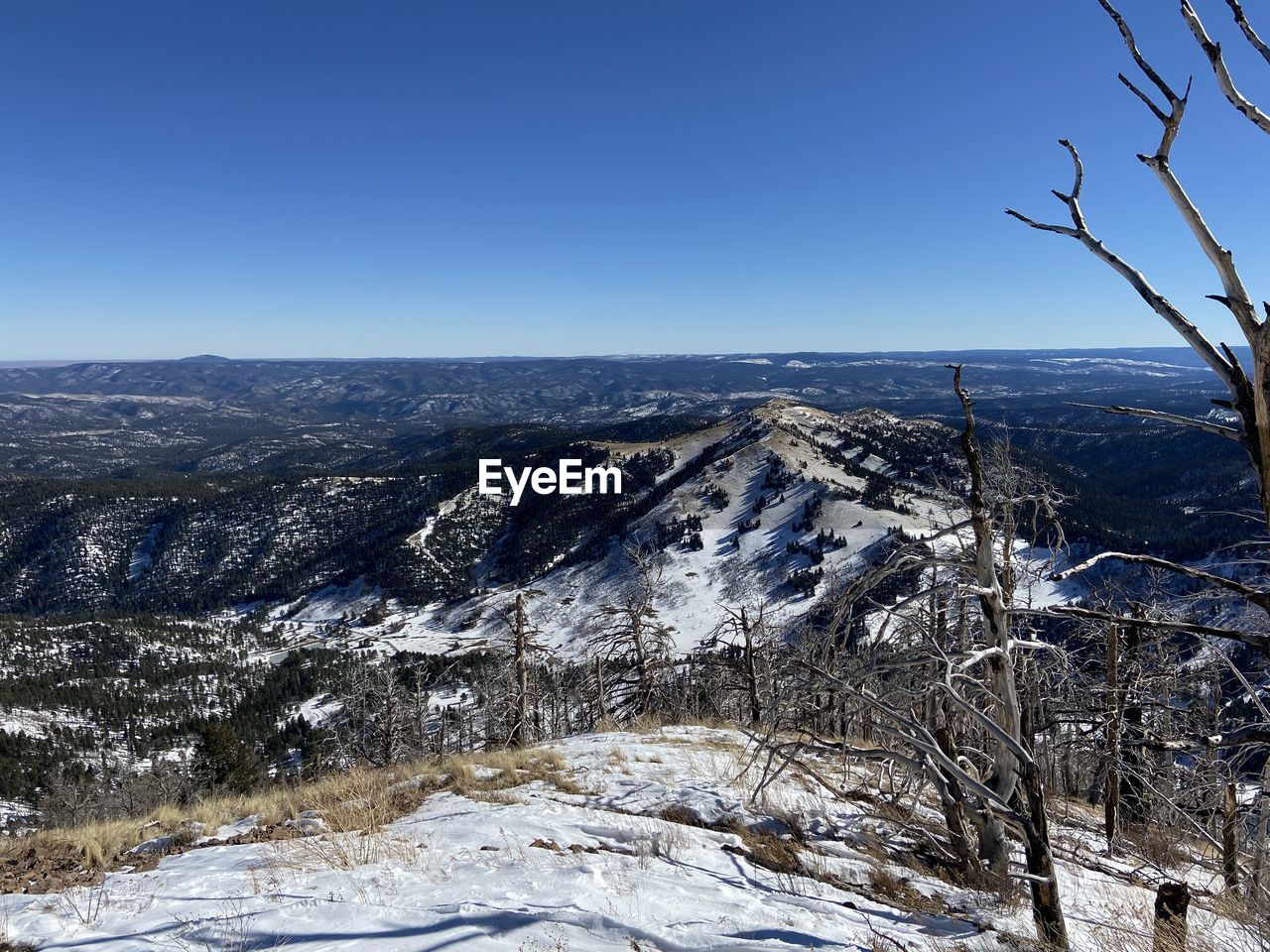 Aerial view of snowcapped mountains against clear sky