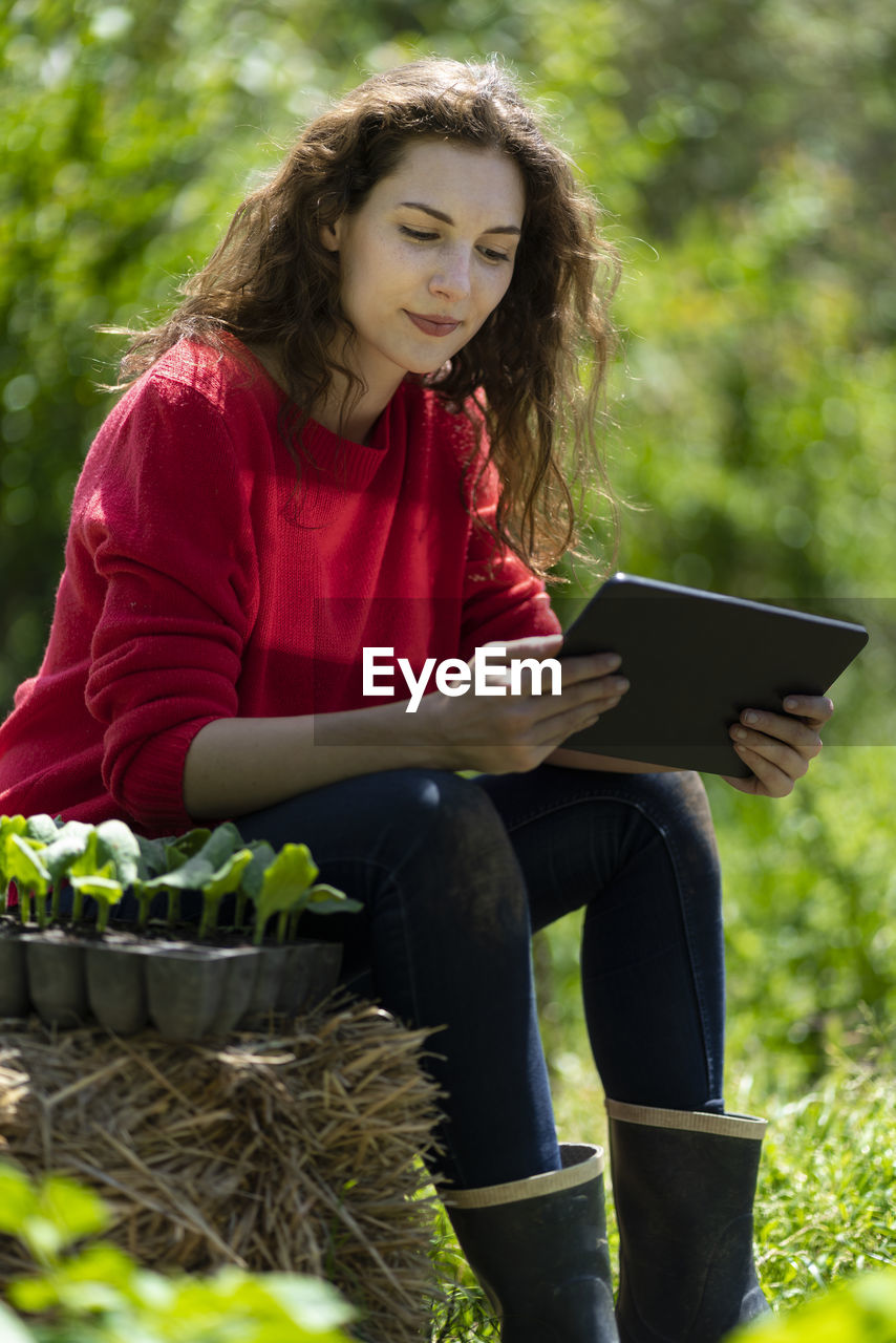 Woman using digital tablet in garden