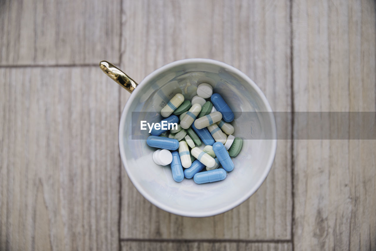 Directly above shot of medicines in cup on table