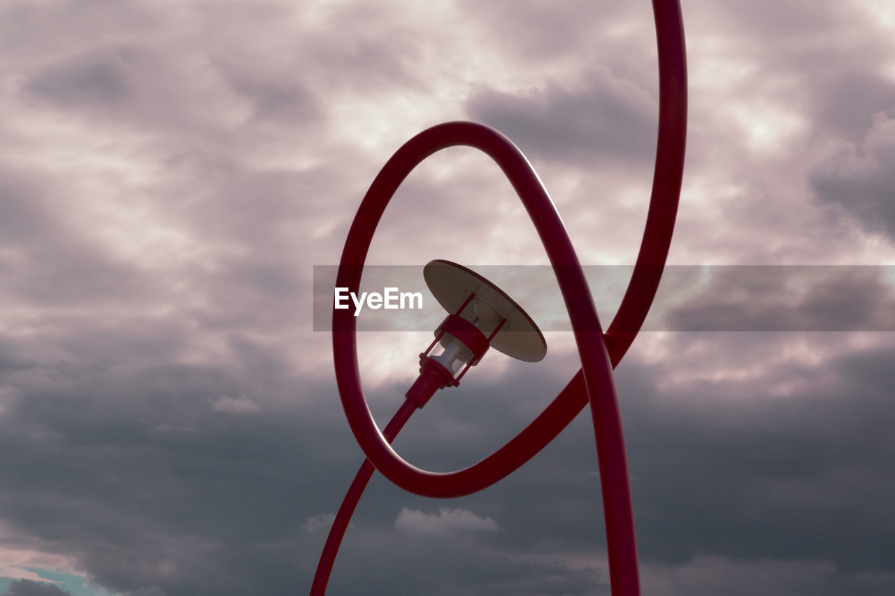 Red danish-design free-form street lamps against evening sky