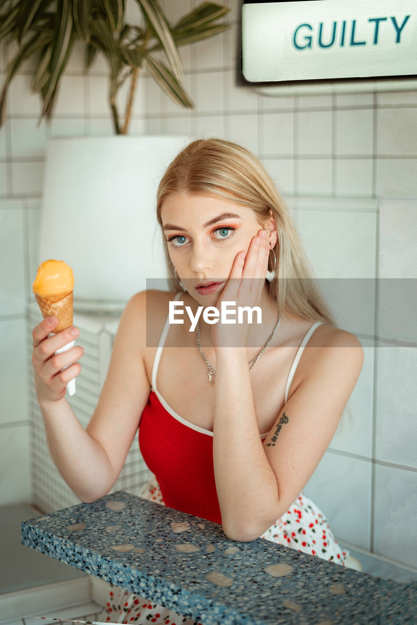Portrait of young woman holding ice cream