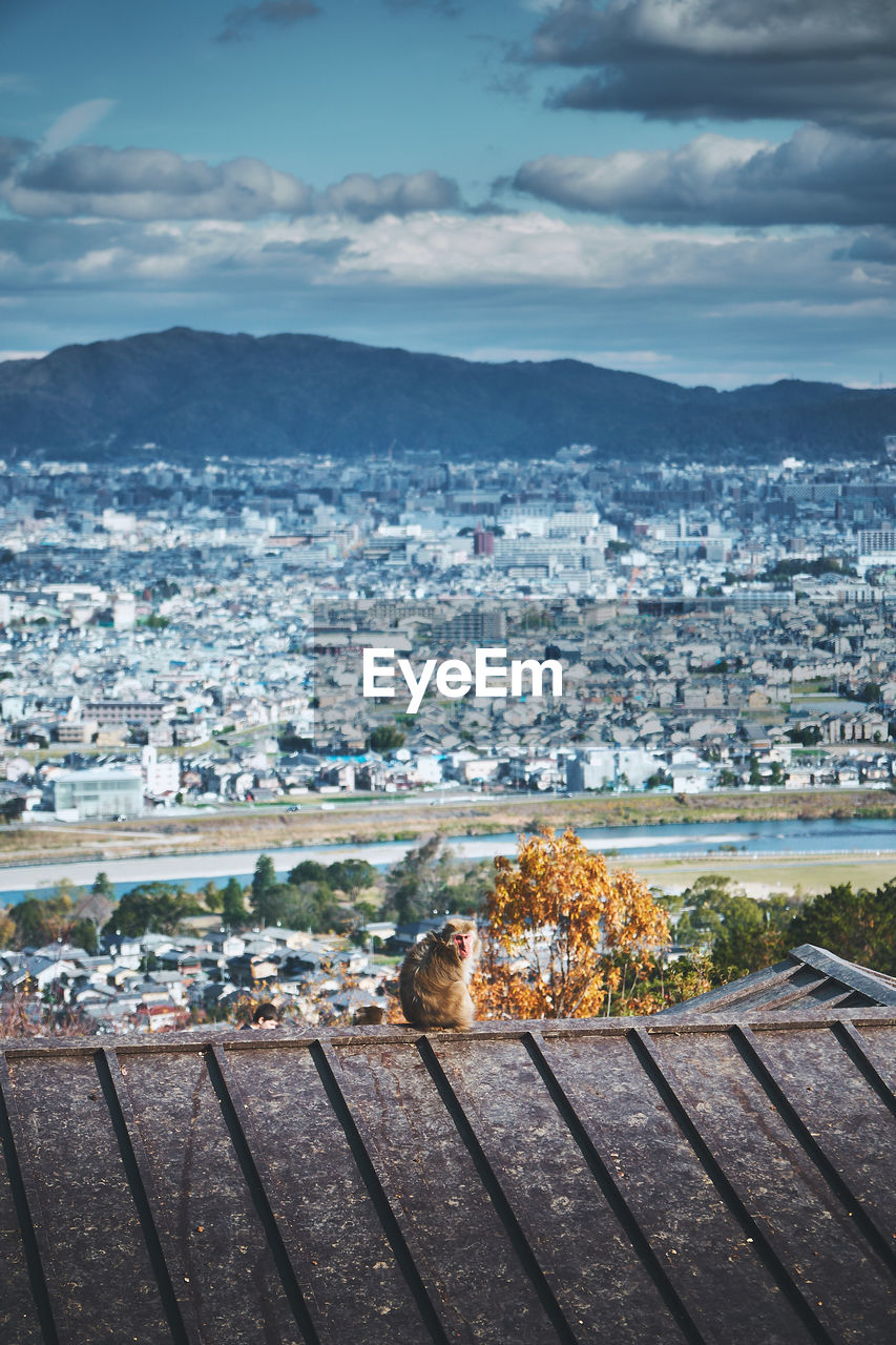 HIGH ANGLE VIEW OF TOWNSCAPE AND MOUNTAINS AGAINST SKY