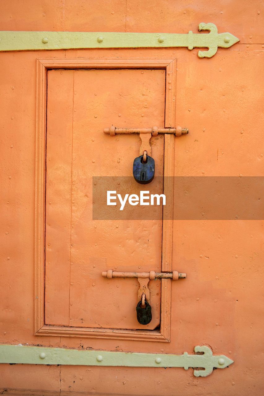 FULL FRAME SHOT OF CLOSED DOOR WITH RED WALL