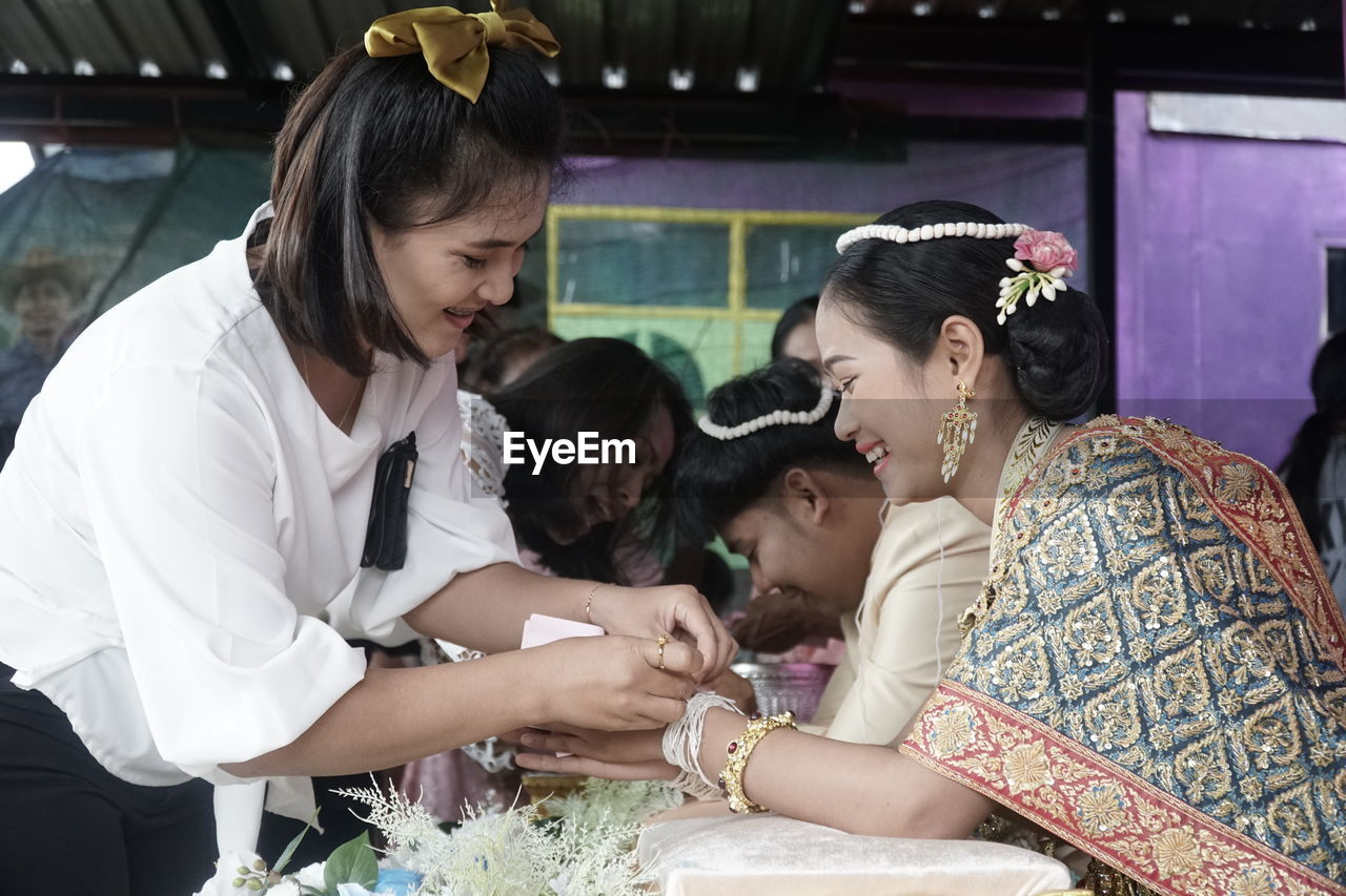 WOMAN AND PEOPLE IN TRADITIONAL CLOTHING AT HOME