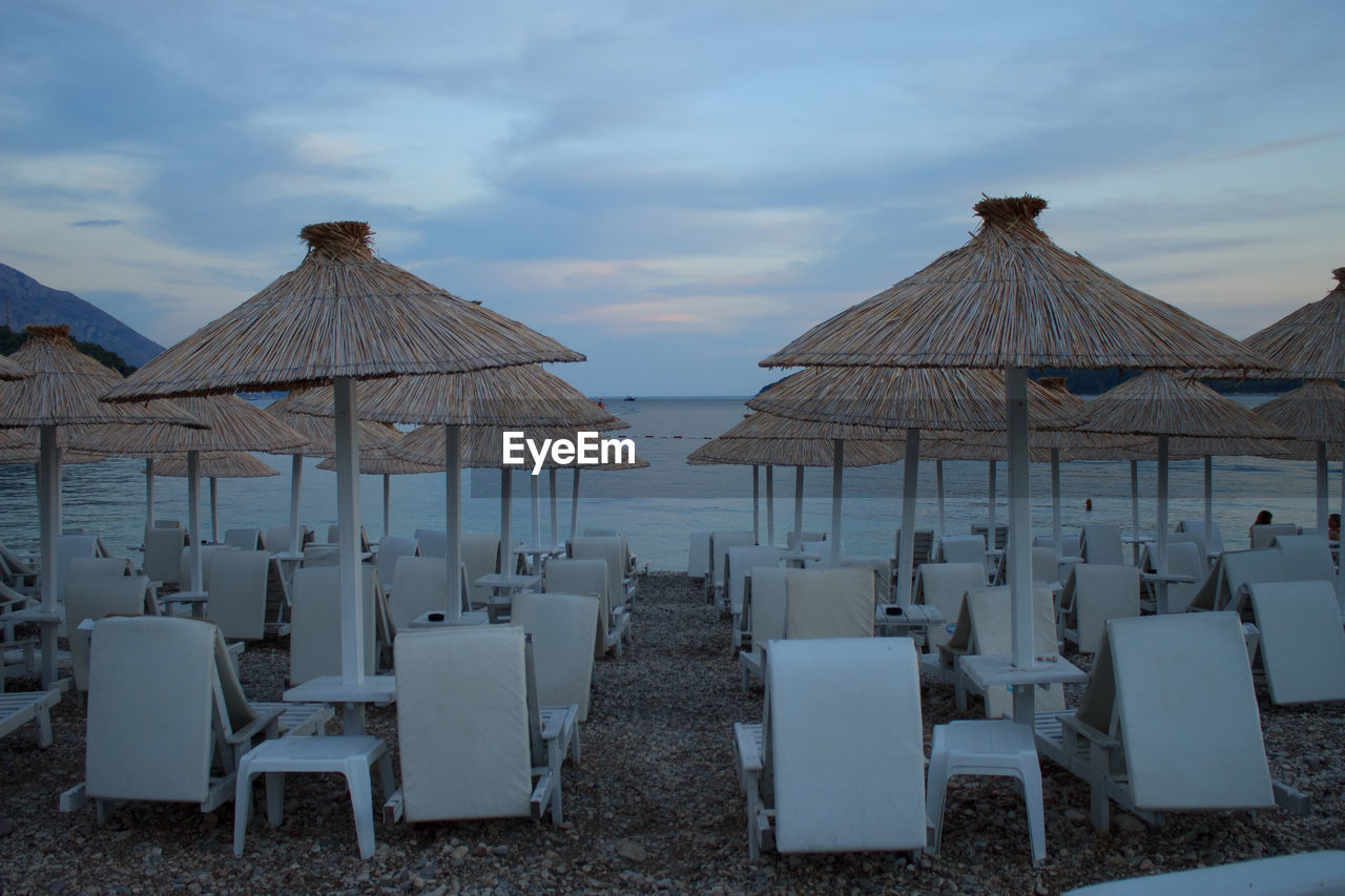 Chairs on beach against sky