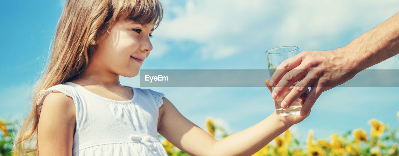 Cropped hand of father giving water glass