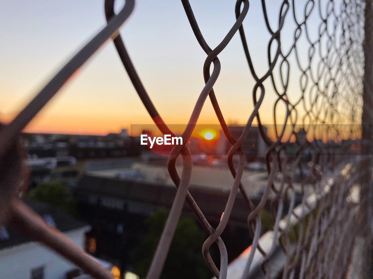 CLOSE-UP OF CHAINLINK FENCE AT SUNSET