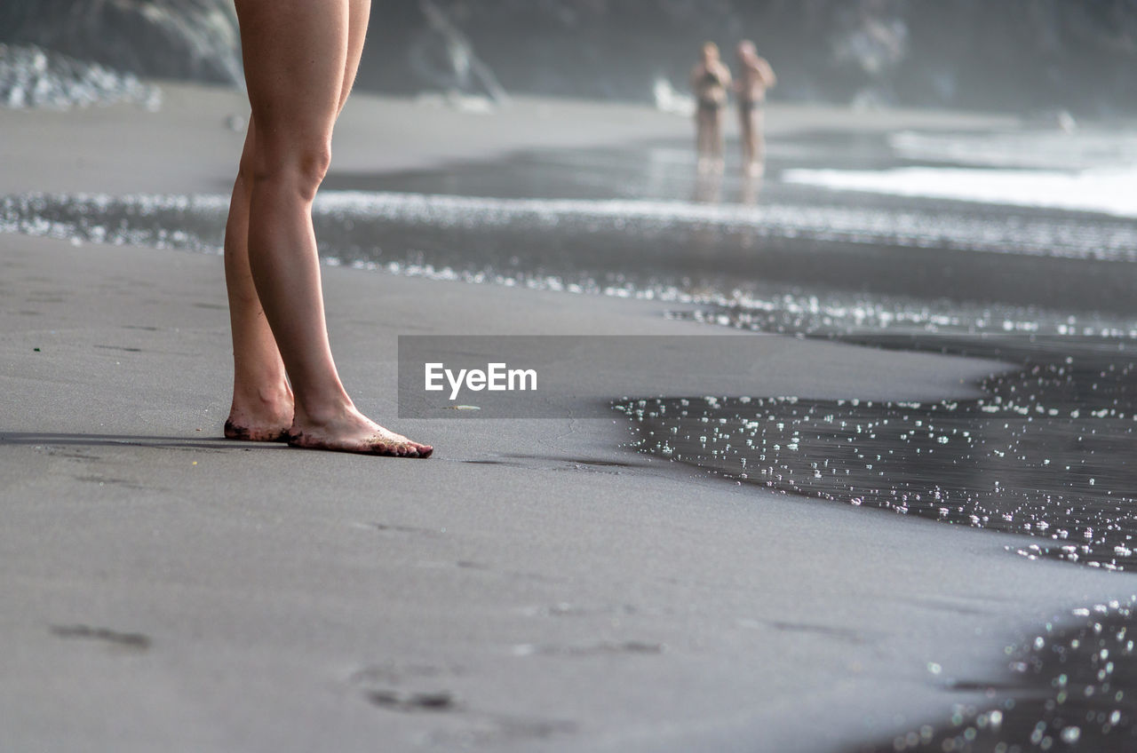 LOW SECTION OF WOMAN WALKING ON WET FLOOR