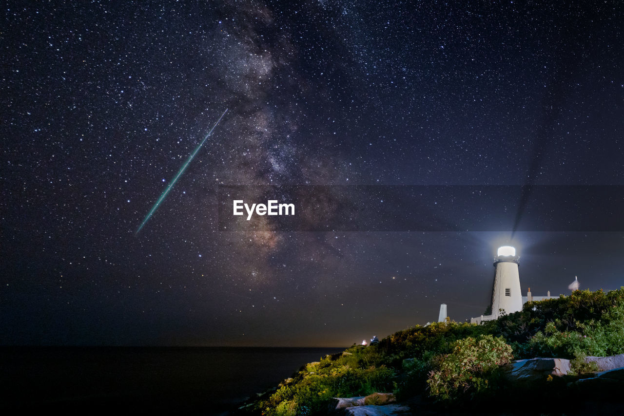 The milkyway and a meteor lights up the night sky off the coast at the pemaquid point lighthouse.  