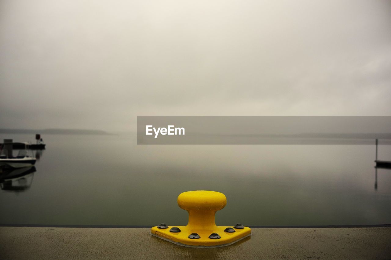 water, sky, yellow, nature, no people, morning, tranquility, sea, absence, reflection, cloud, light, tranquil scene, copy space, nautical vessel, beauty in nature, vehicle, scenics - nature, outdoors, transportation, day, fog, overcast, vignette, beach