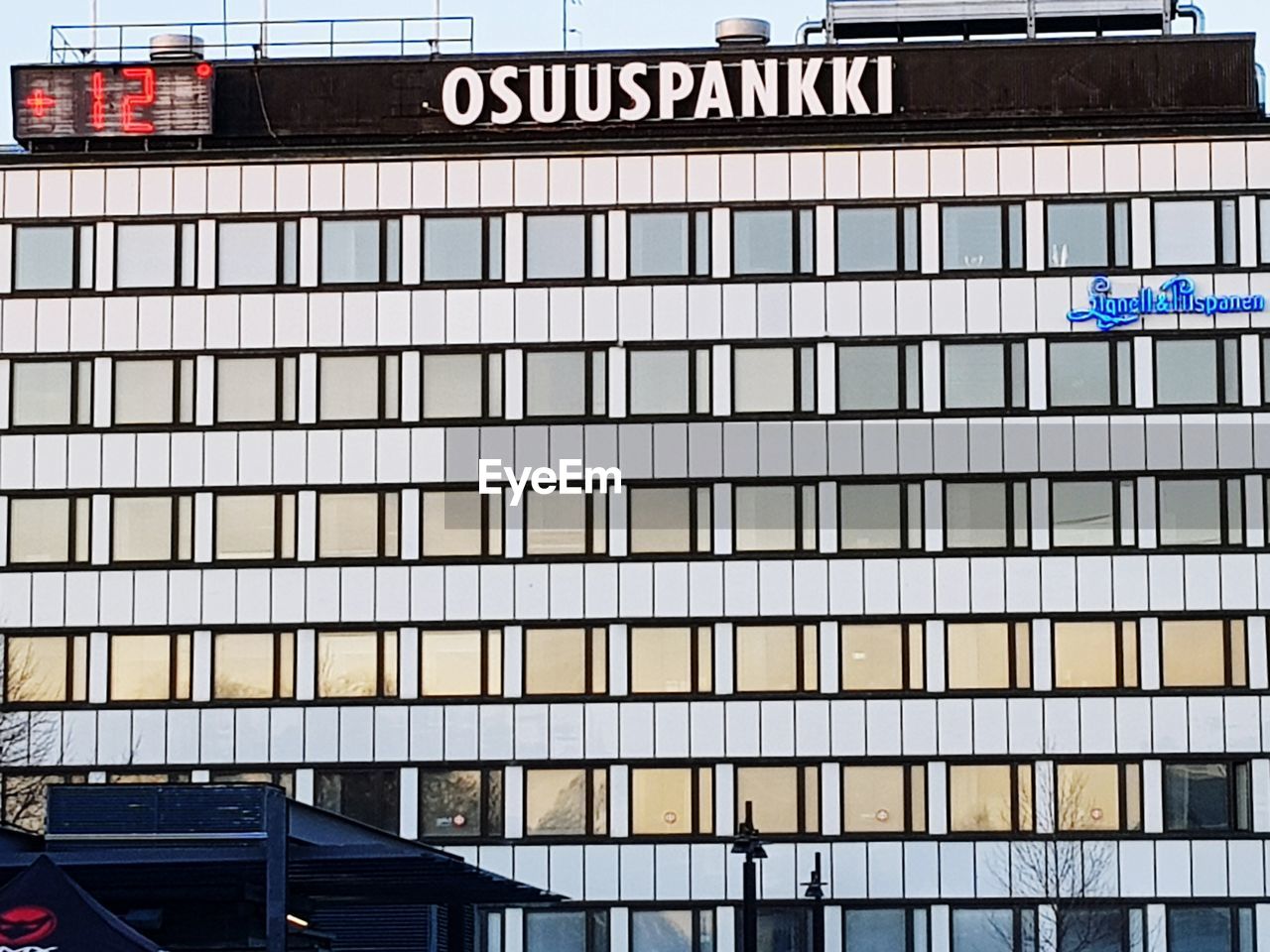 architecture, built structure, building exterior, city, building, day, text, communication, sign, no people, window, transportation, outdoors, low angle view, western script, glass - material, mode of transportation, office building exterior, road, road sign