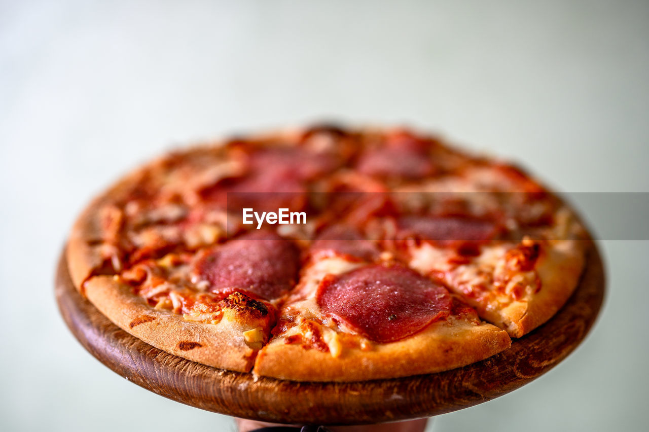 Close-up of pizza on table against white background