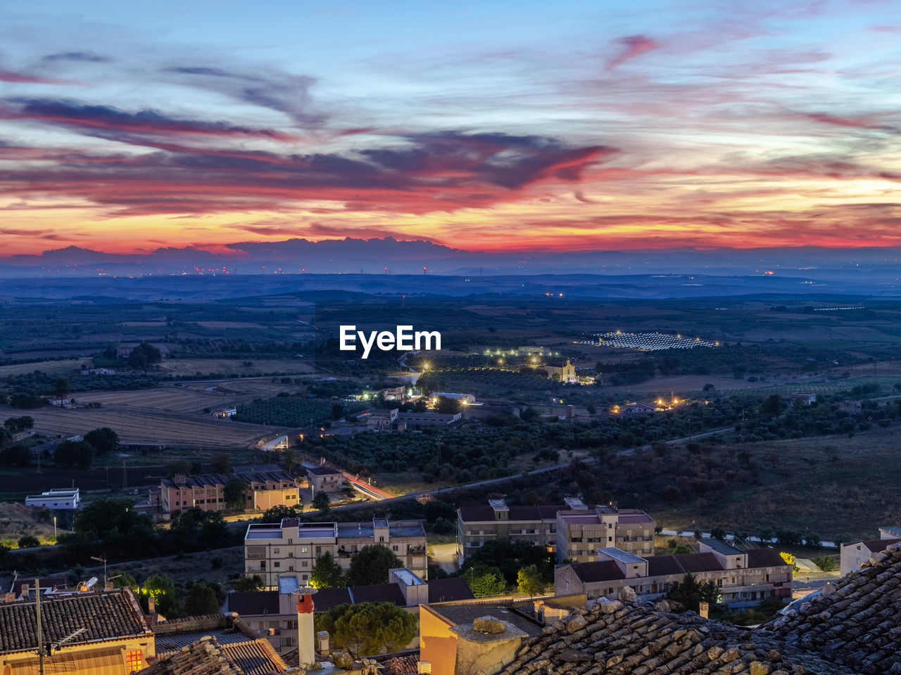 HIGH ANGLE SHOT OF TOWNSCAPE AGAINST SKY DURING SUNSET