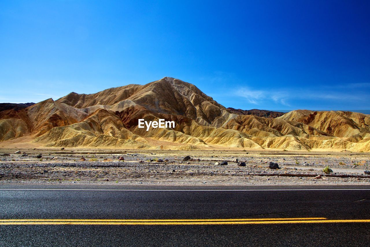 Scenic view of desert against clear blue sky