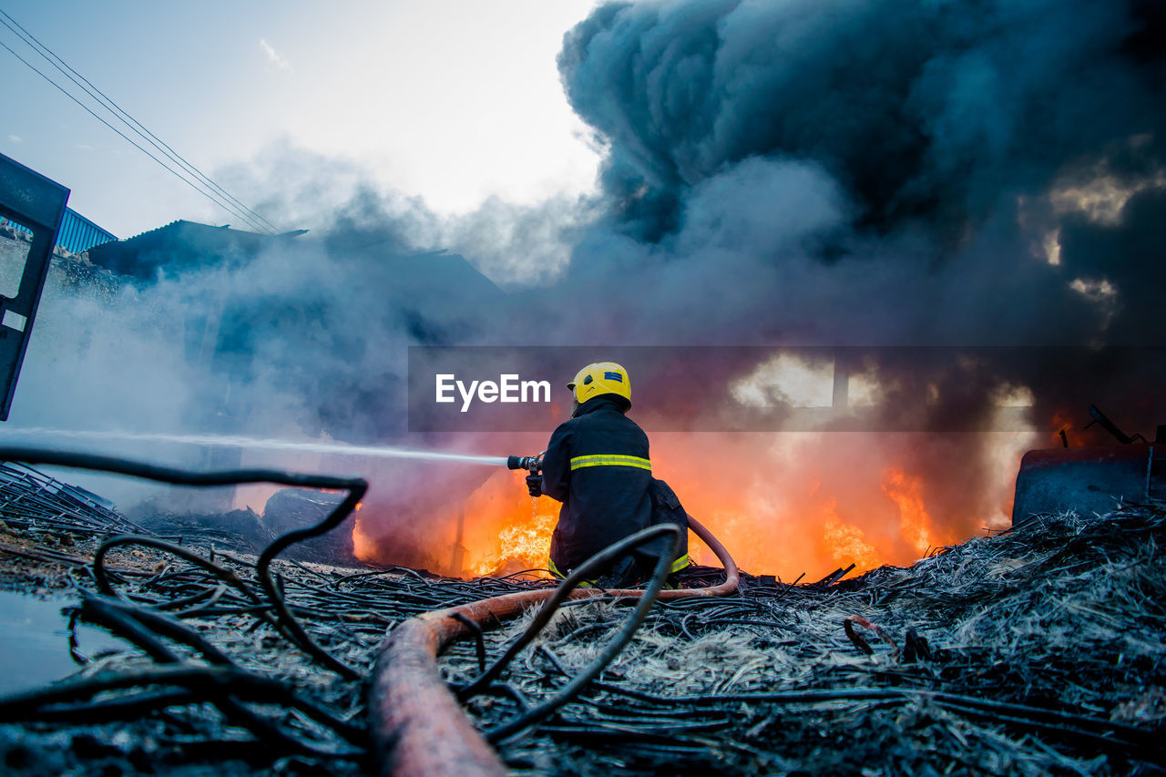 Back view of fireman combating industrial fire