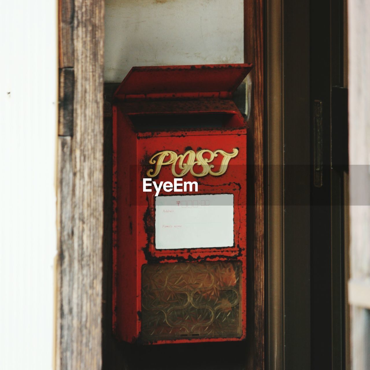 Close-up of red mailbox on door