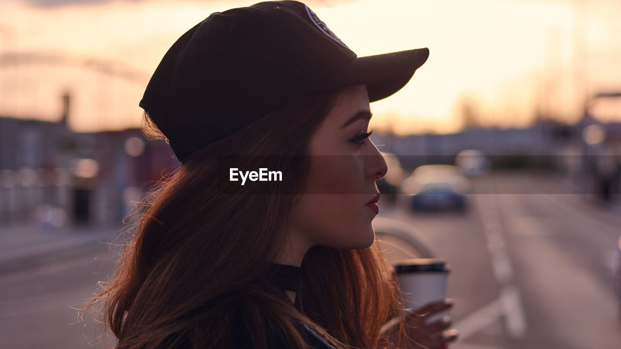 Close-up of woman on city street at sunrise