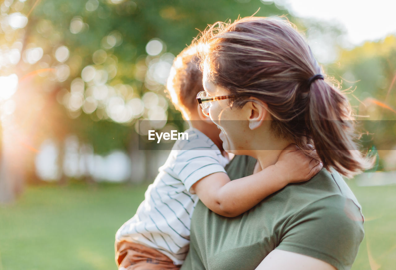 Mother and diverse mixed race toddler so. at park having fun bonding together