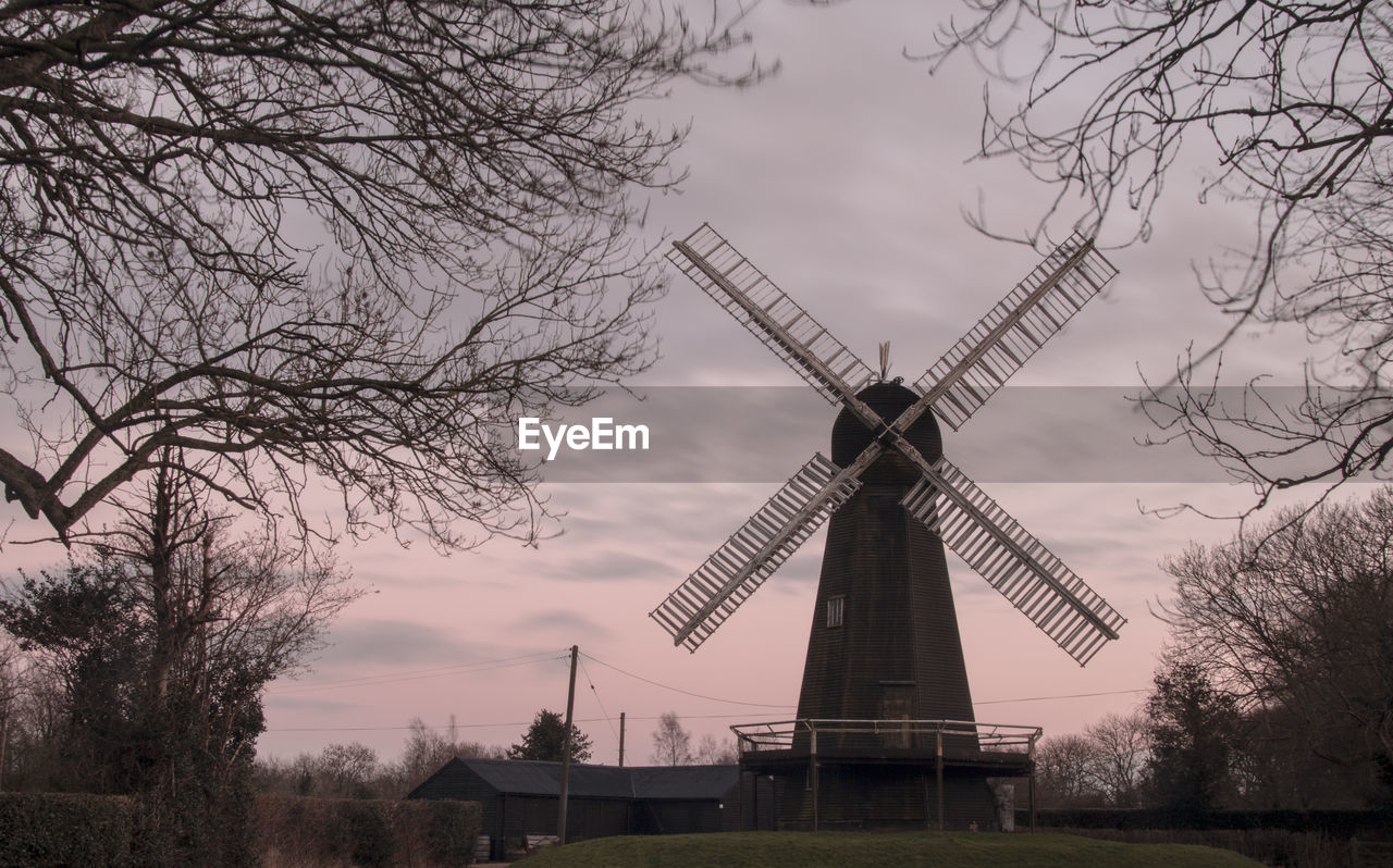 Low angle view of windmill on field against sky