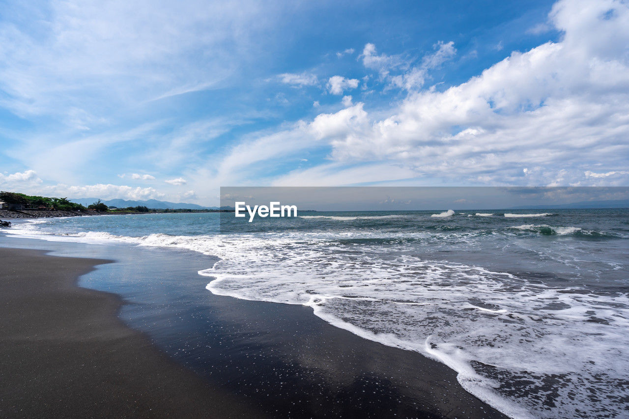 sea, water, land, sky, beach, cloud, ocean, wind wave, body of water, wave, scenics - nature, beauty in nature, nature, environment, horizon, shore, sand, landscape, coast, travel destinations, motion, travel, surfing, coastline, water sports, blue, sports, tourism, outdoors, horizon over water, holiday, tranquility, trip, seascape, vacation, water's edge, tropical climate, day, tranquil scene, island, summer, cloudscape, tide, idyllic