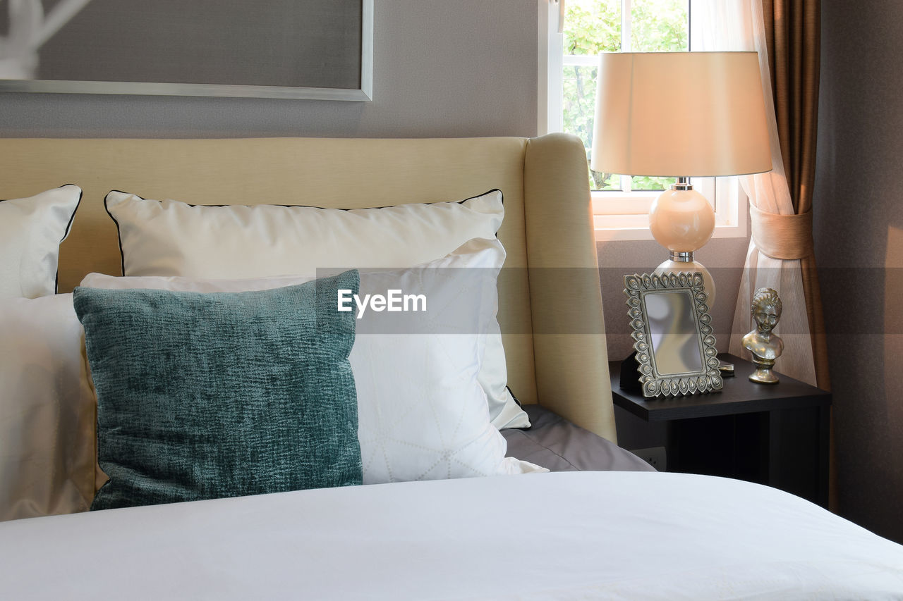 Cushion and pillows on bed in bedroom