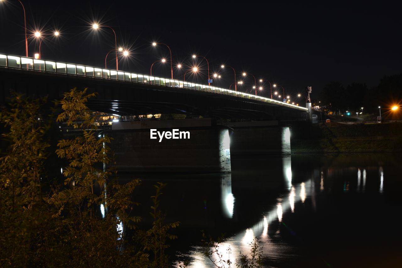 VIEW OF BRIDGE OVER RIVER AT NIGHT