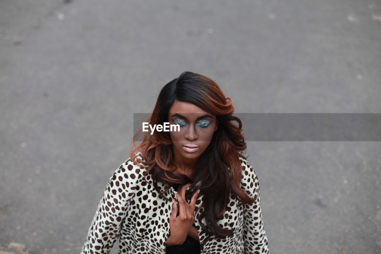 Young woman with eye make-up on road