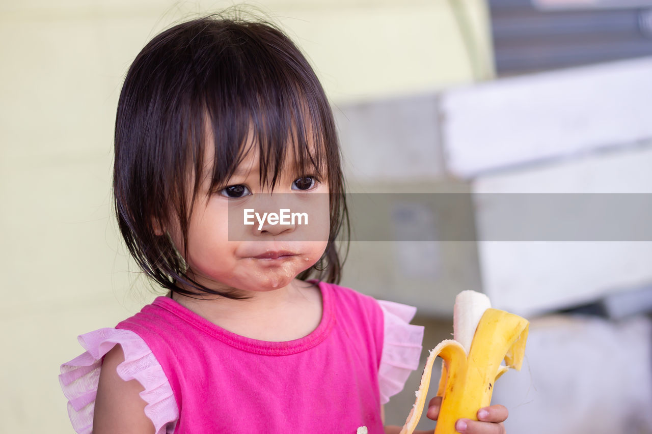 Cute baby girl eating banana