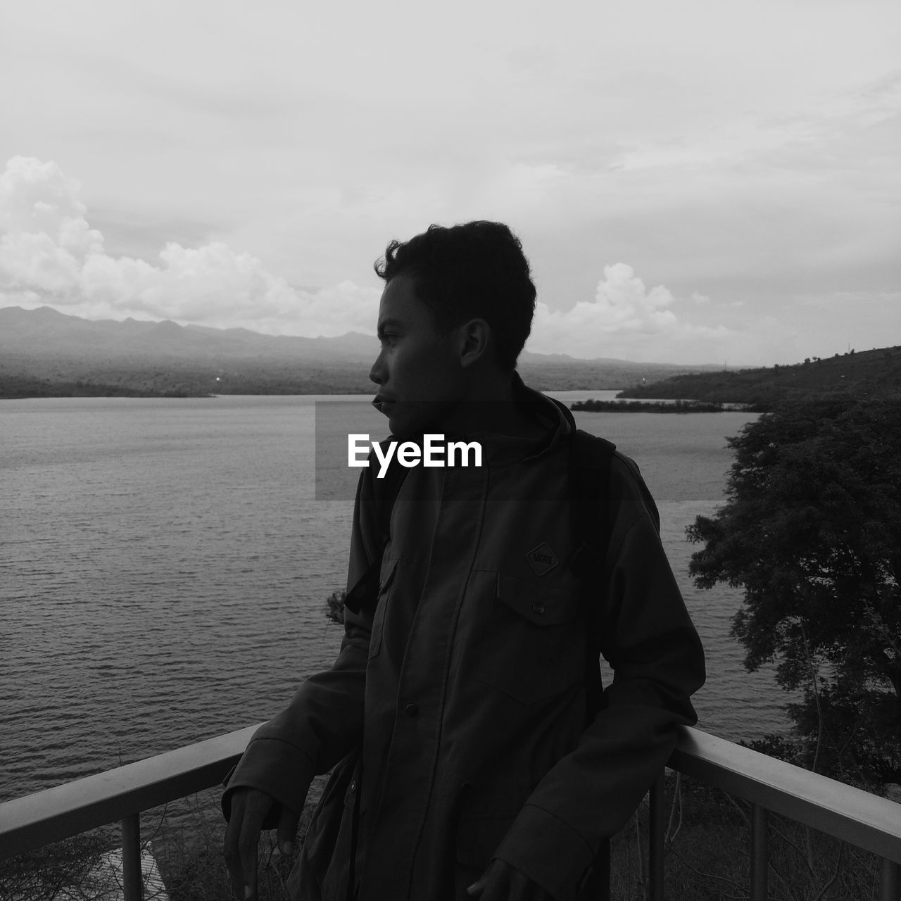 Man looking at lake against sky