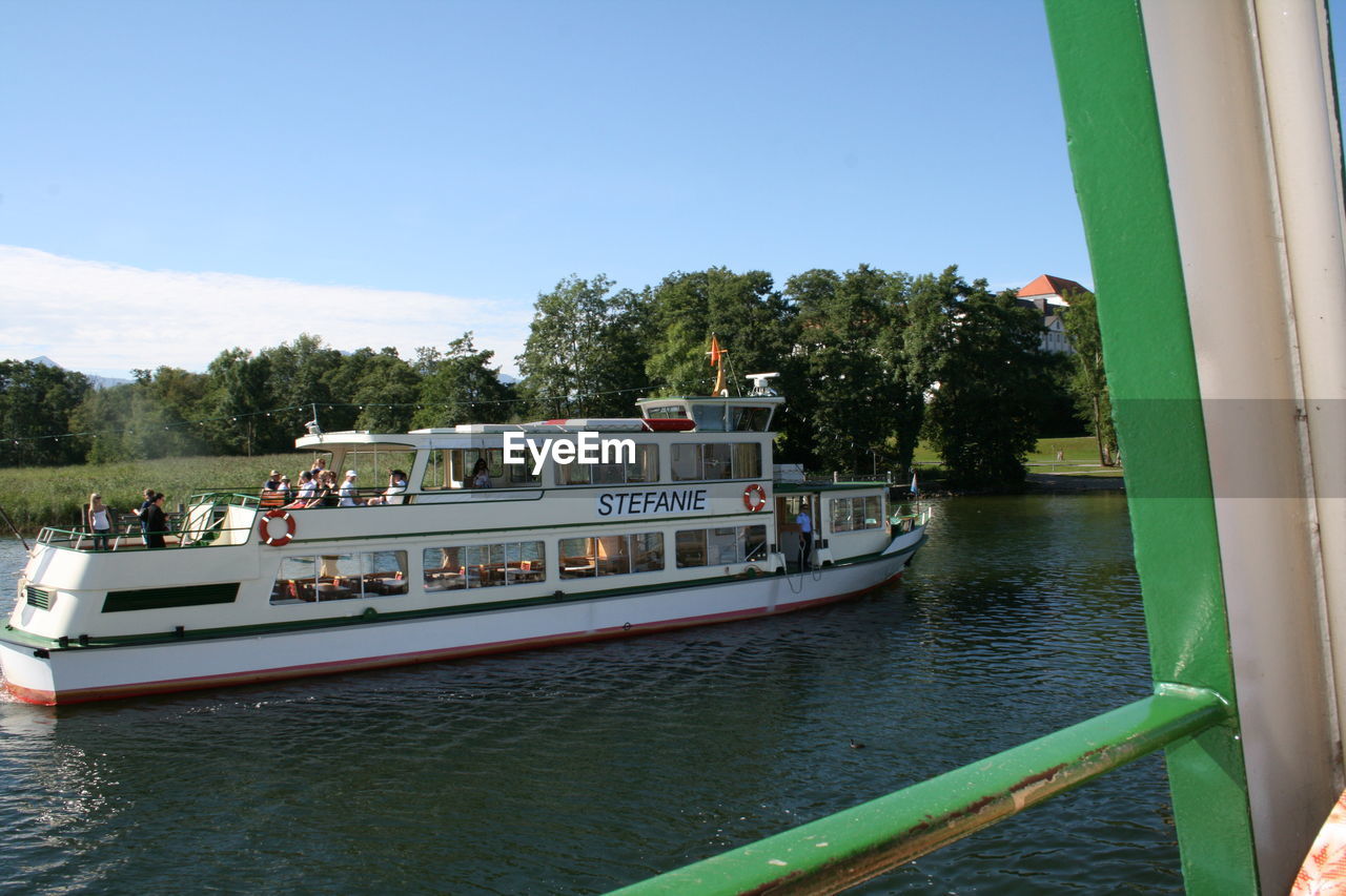 BOATS SAILING IN RIVER AGAINST CLEAR SKY