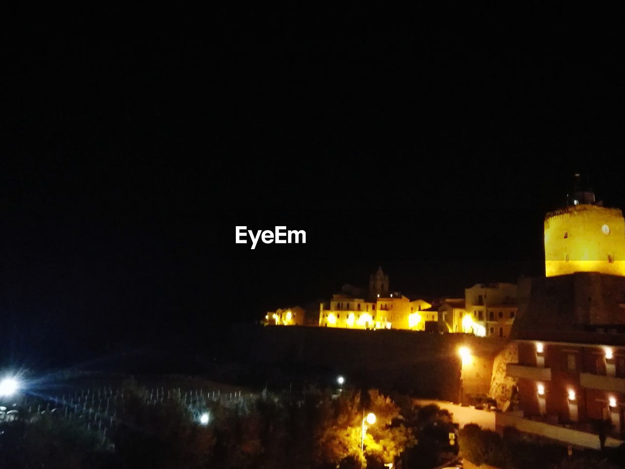 ILLUMINATED BUILT STRUCTURES AGAINST CLEAR SKY AT NIGHT