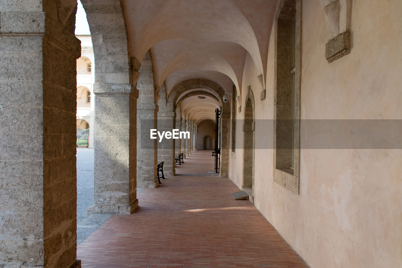 EMPTY CORRIDOR OF BUILDING WITH COLUMNS