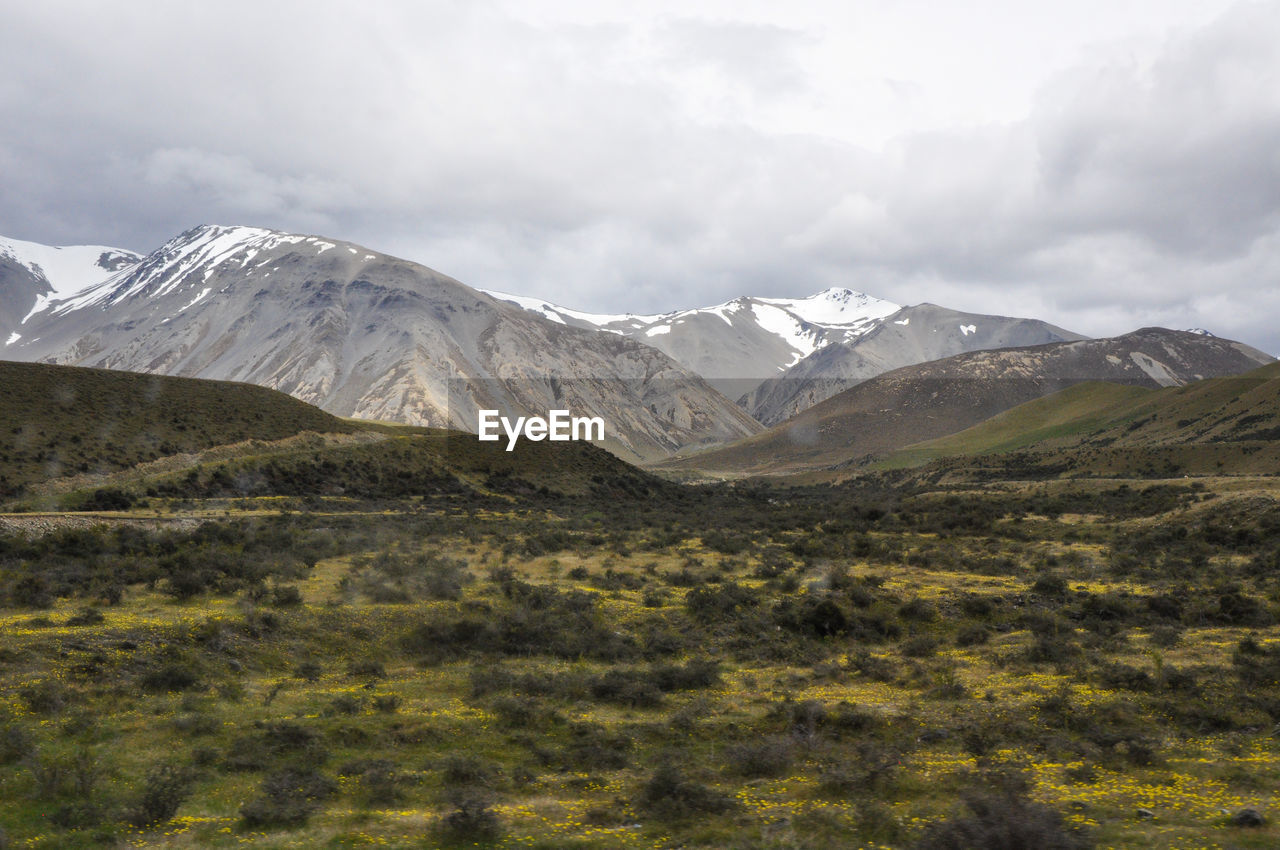 Scenic view of mountains against cloudy sky