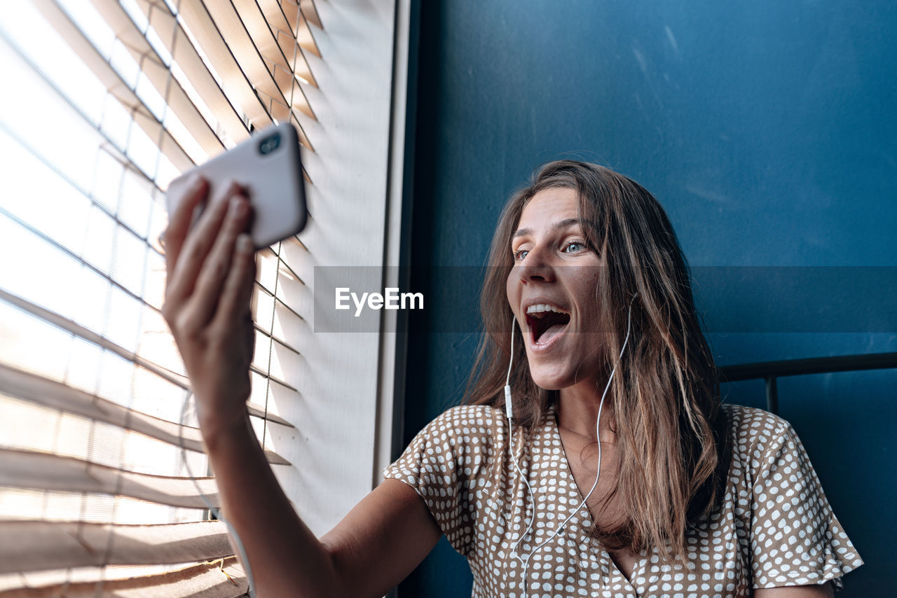 Woman on video call while sitting by window