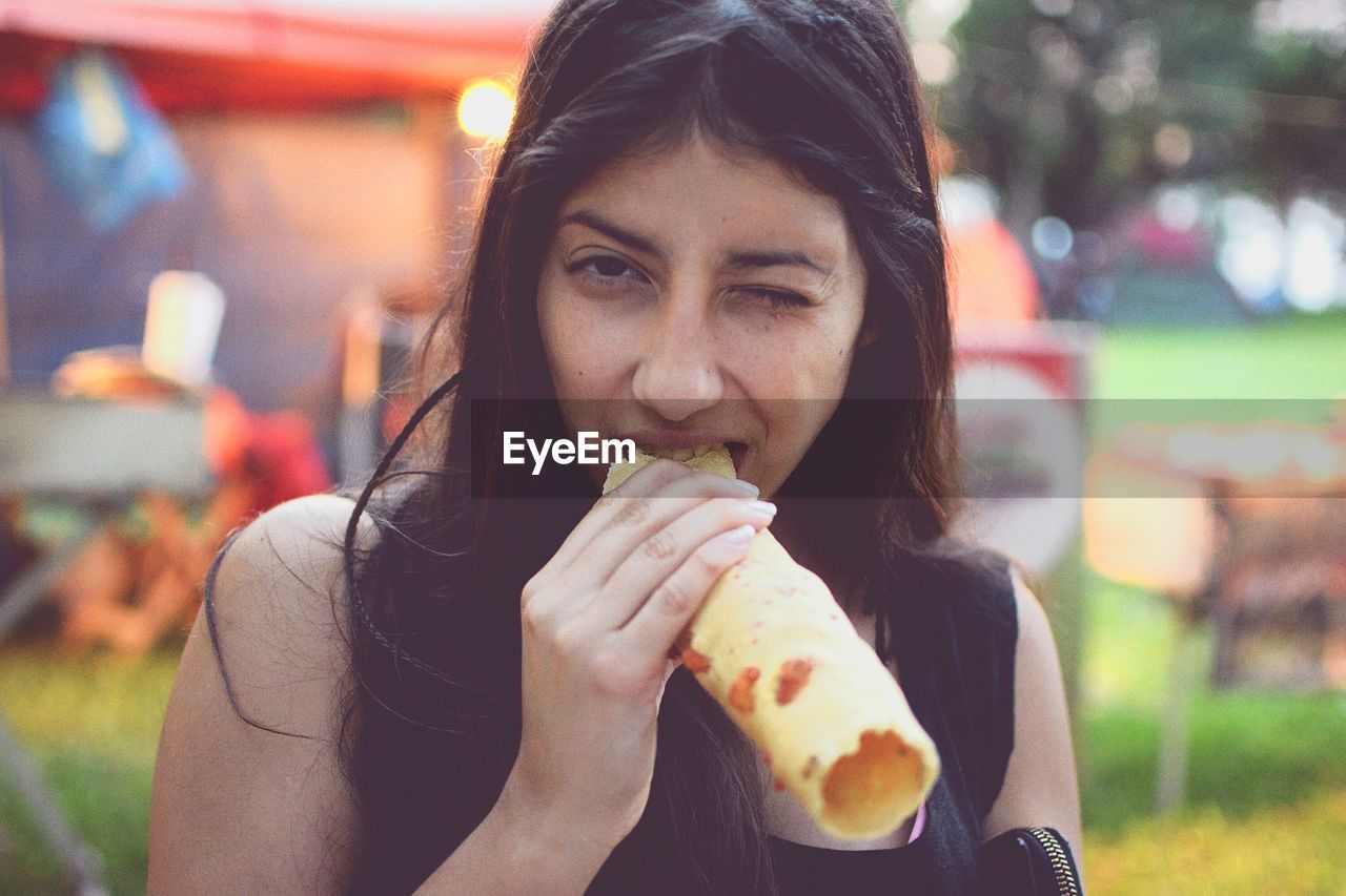 Portrait of young woman eating