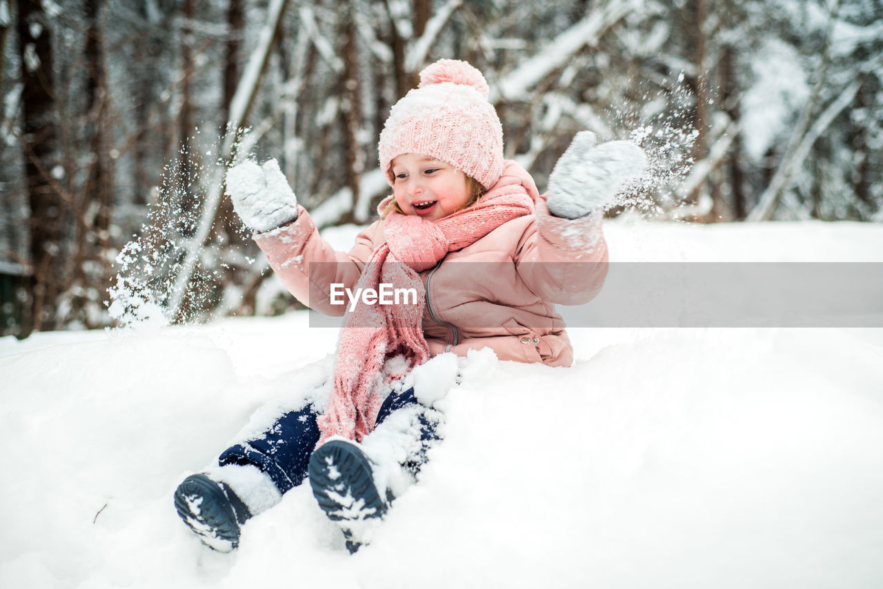 Cute girl playing with snow during winter