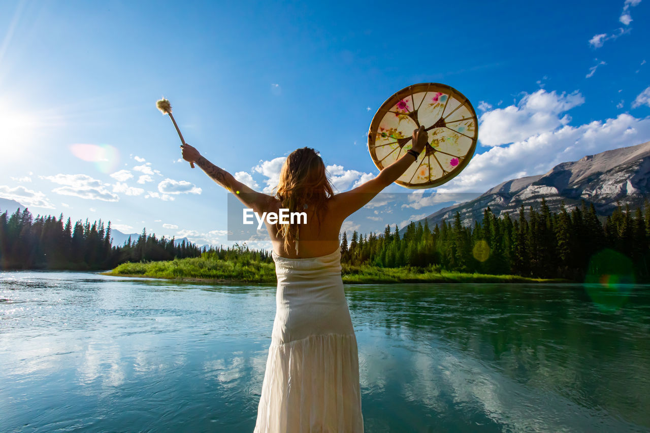 WOMAN STANDING BY LAKE