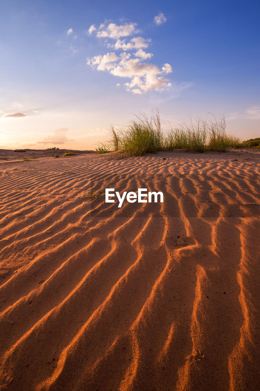 SAND DUNE IN DESERT AGAINST SKY DURING SUNSET