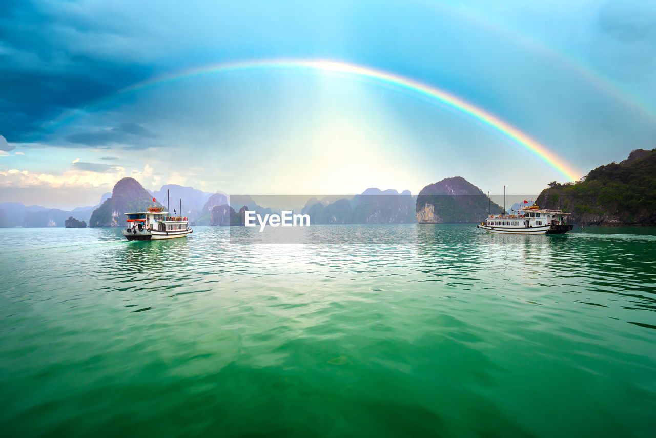 SCENIC VIEW OF SEA AGAINST RAINBOW IN SKY