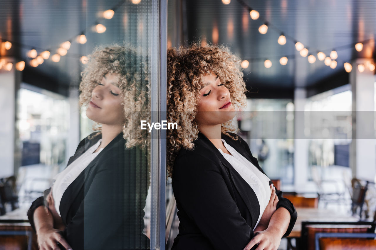 Portrait of relaxed business woman with eyes closed in cafe leaning on glass. business concept