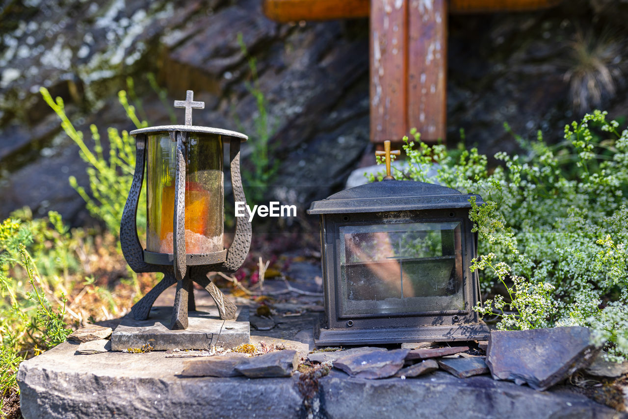 Two metal candles with glass sides standing in a chapel on a mountain trail.