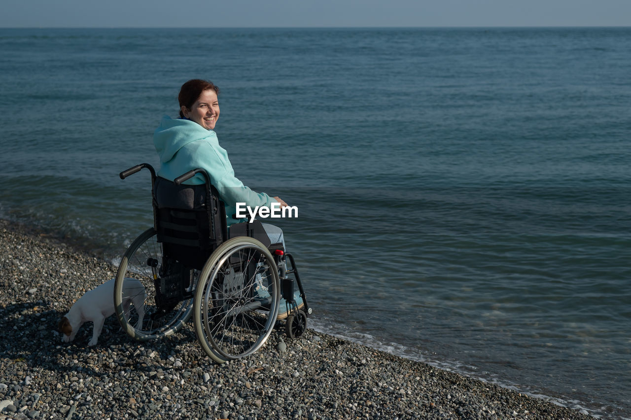 Pacified caucasian woman in a wheelchair on the seashore