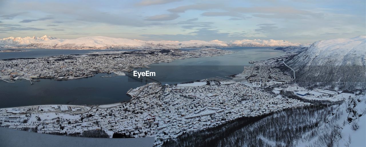 Aerial view of frozen lake by snowcapped mountain against sky